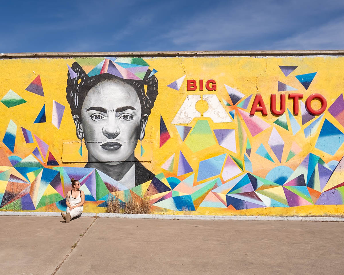 Woman sitting near a mural of Frida Kahlo in Marfa, Texas