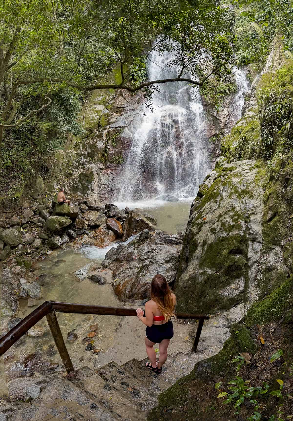 Woman standing on a staircase looking at Marinka Waterfall in Minca, Colombia