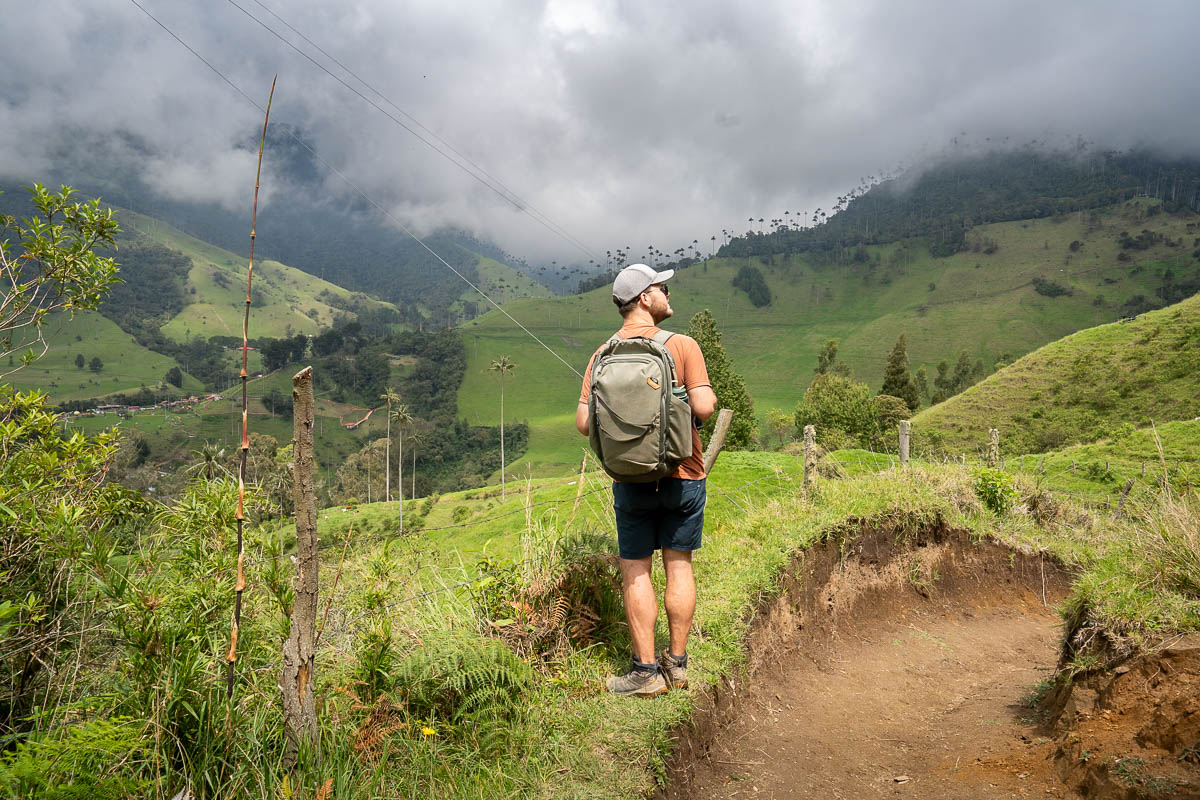 Man standing along the Cerro Morrogacho trail with the Cocora Valley in the background near Salento, Colombia