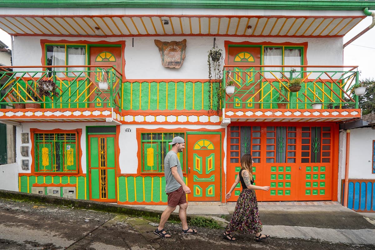 Couple walking in front of a colorful building in Salento, Colombia