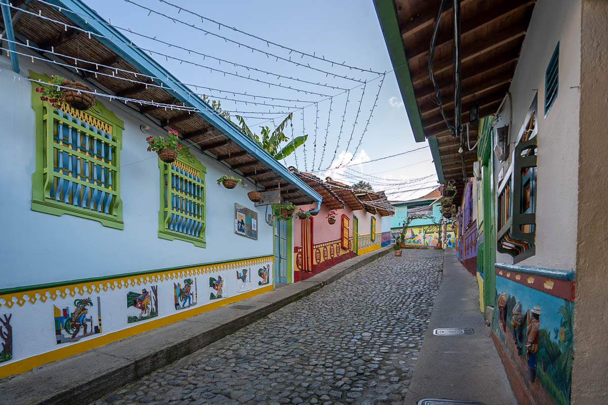 Colorful buildings with zócalos lining a cobblestone street in Guatape, Colombia