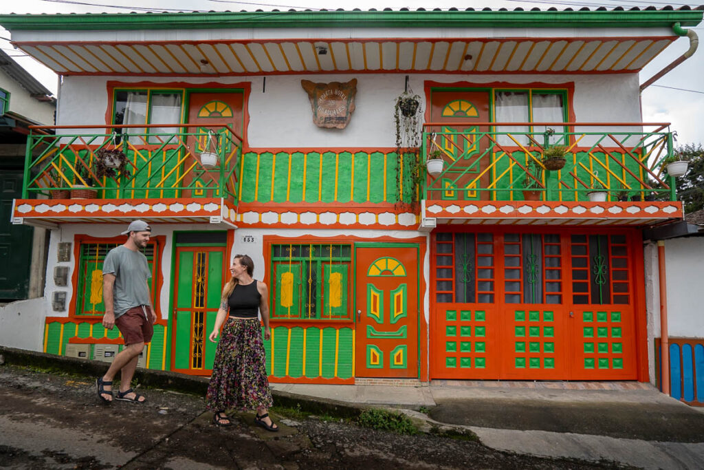 Couple walking in front of a colorful building in Salento, Colombia