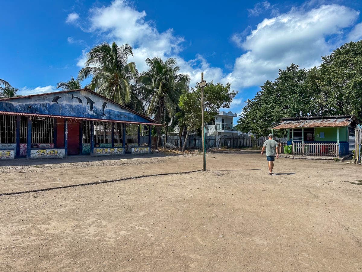 Man walking next to buildings in Orika on Isla Grande in Colombia