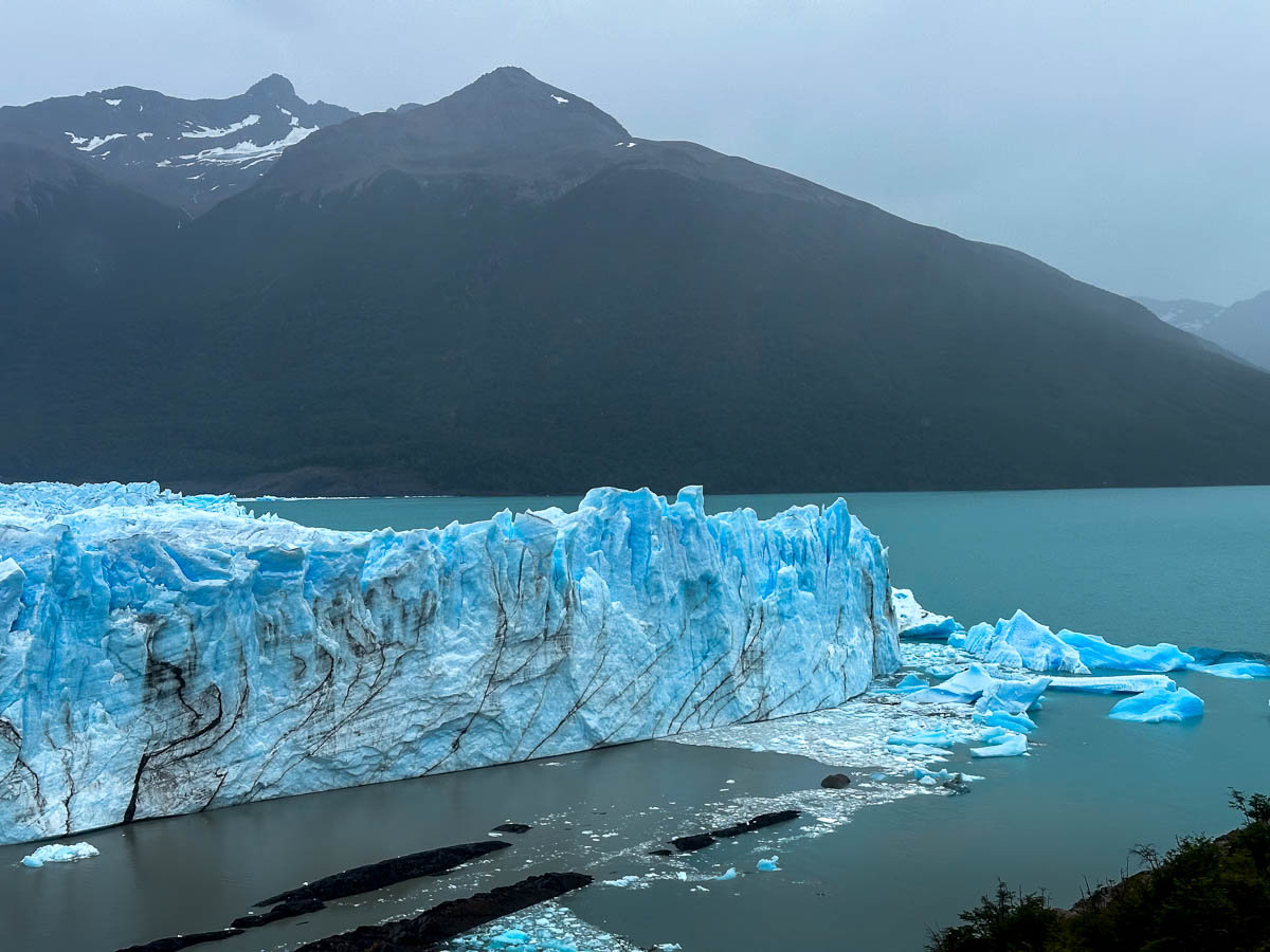 Northern face of the Perito Moreno glacier with a mountain in the background along the Sendero de la Costa trail in Los Glaciares National Park near El Calafate, Argentina