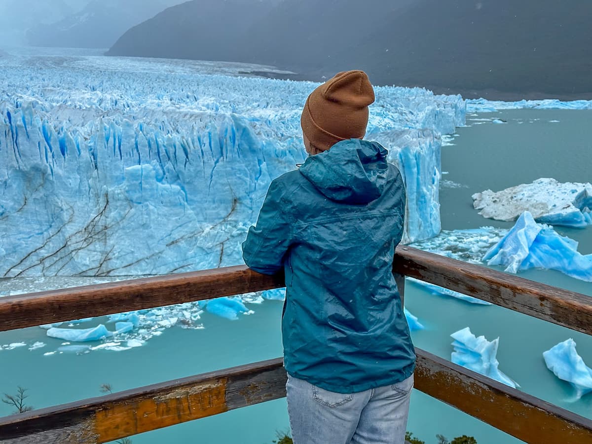 Woman overlooking the Perito Moreno glacier from a balcony from the Sendero Central trail in Los Glaciares National Park near El Calafate, Argentina