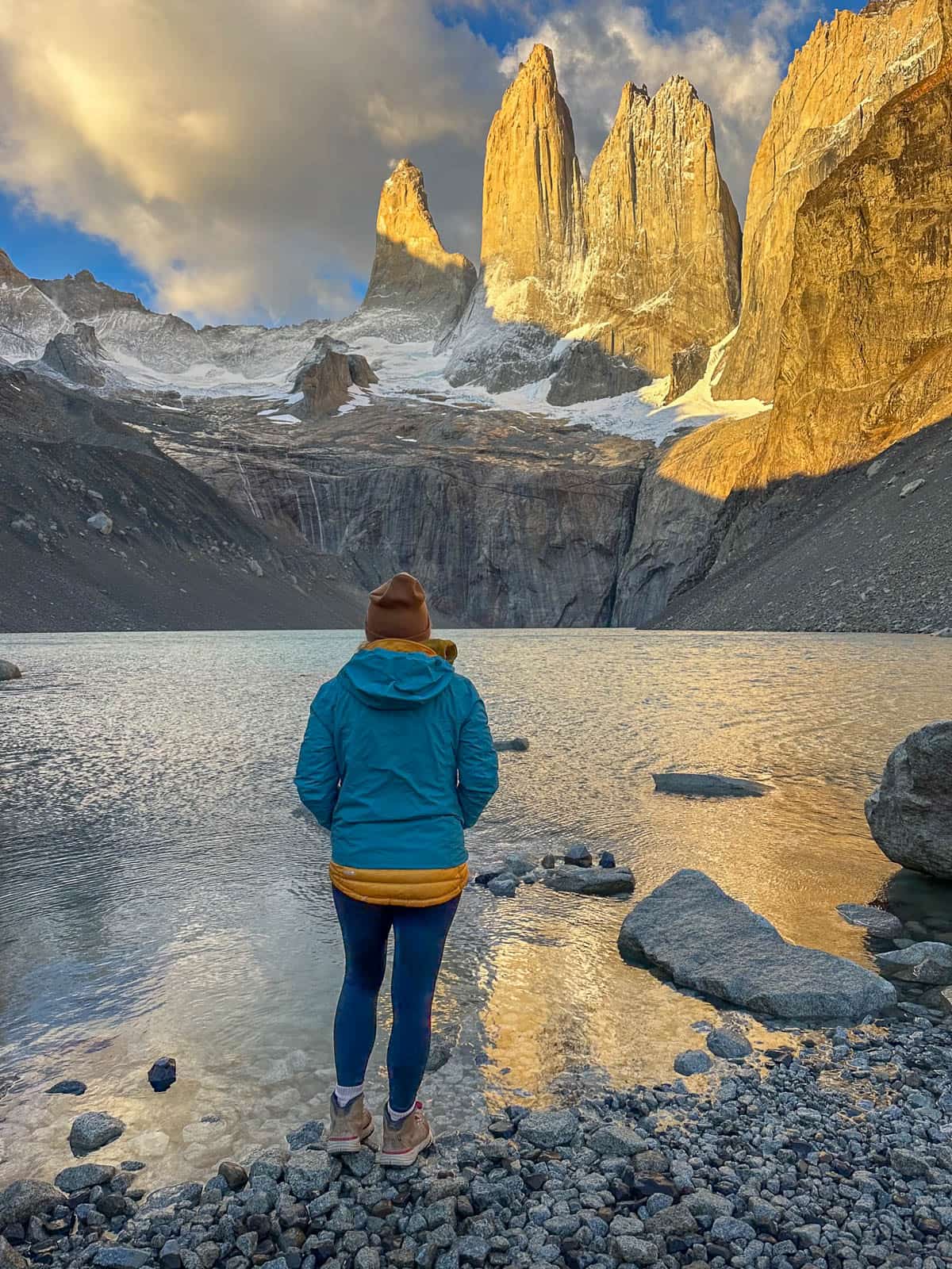Woman looking at Torres del Paine at sunrise in Torres del Paine National Park in Chile