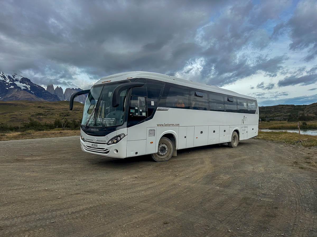 Hotel Las Torres shuttle bus in front of mountains in Torres del Paine National Park in Chilean Patagonia