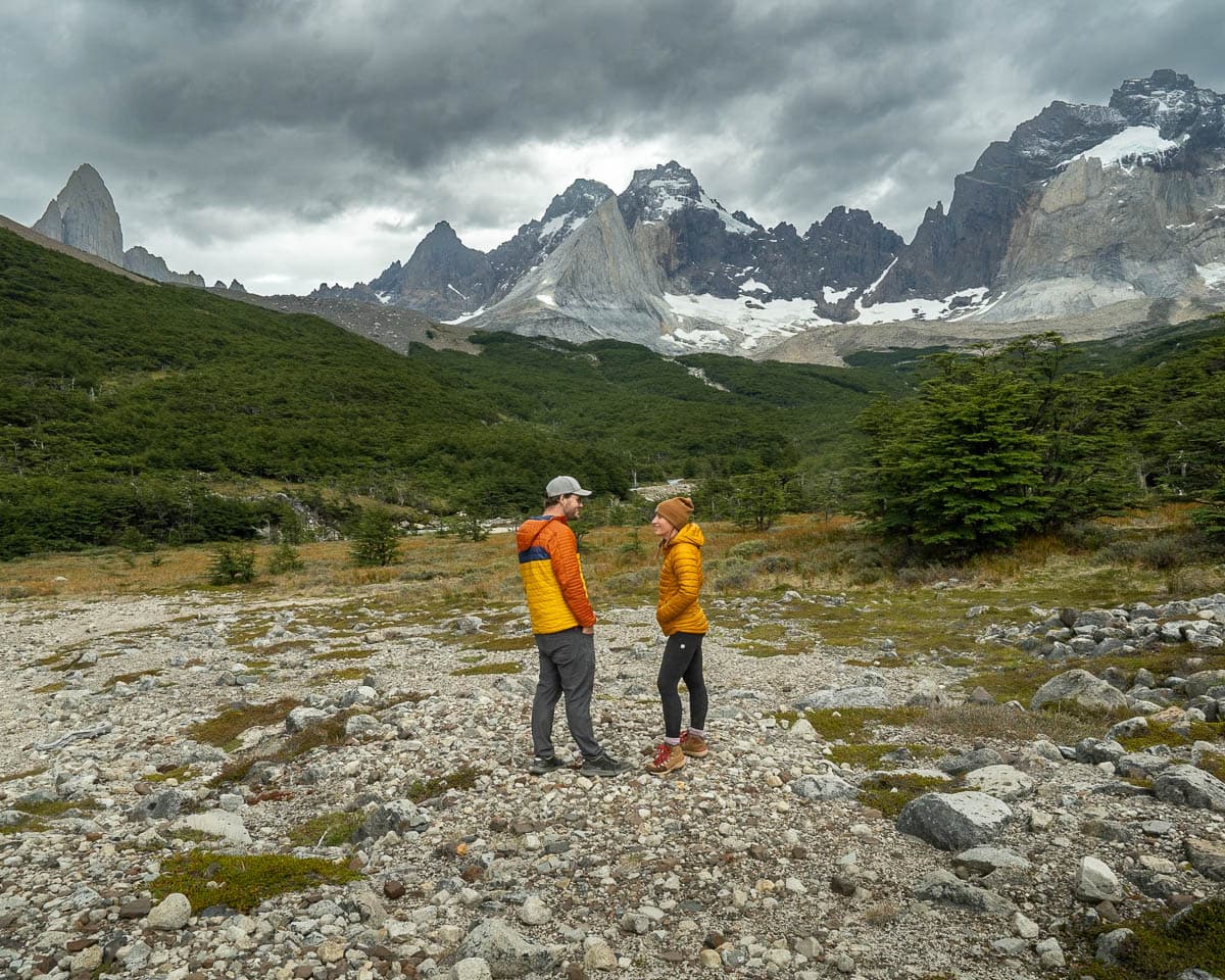 Couple standing in front of mountains on the way to Mirador Britanico along the W Trek in Torres del Paine National Park in Chilean Patagonia