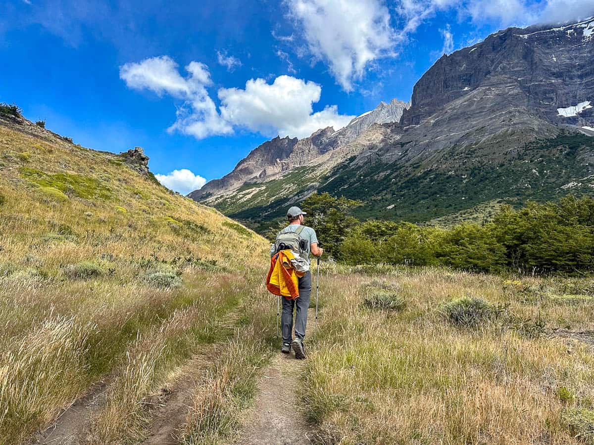Man hiking along the W Trek with mountains in the background in Torres del Paine National Park in Chilean Patagonia