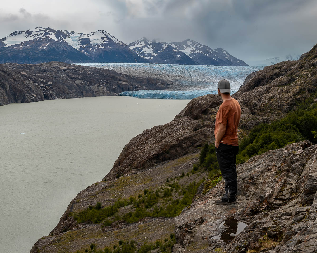Man standing at Mirador Grey looking at Glacier Grey with mountains in the background along the W Trek in Torres del Paine National Park in Chilean Patagonia