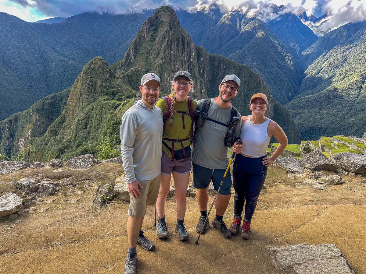 Four hikers smiling in front of Machu Picchu after completing the Inca Trail in Peru 