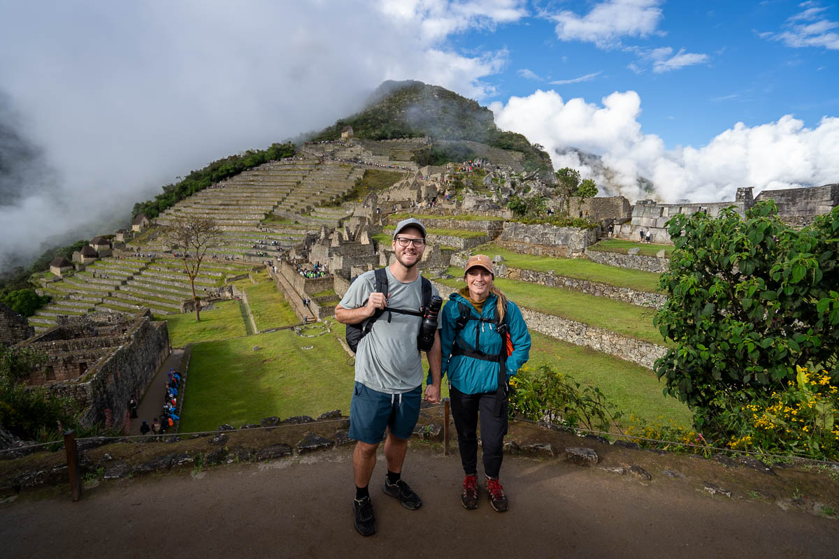 Smiling couple with agricultural terrace ruins in Machu Picchu in Peru