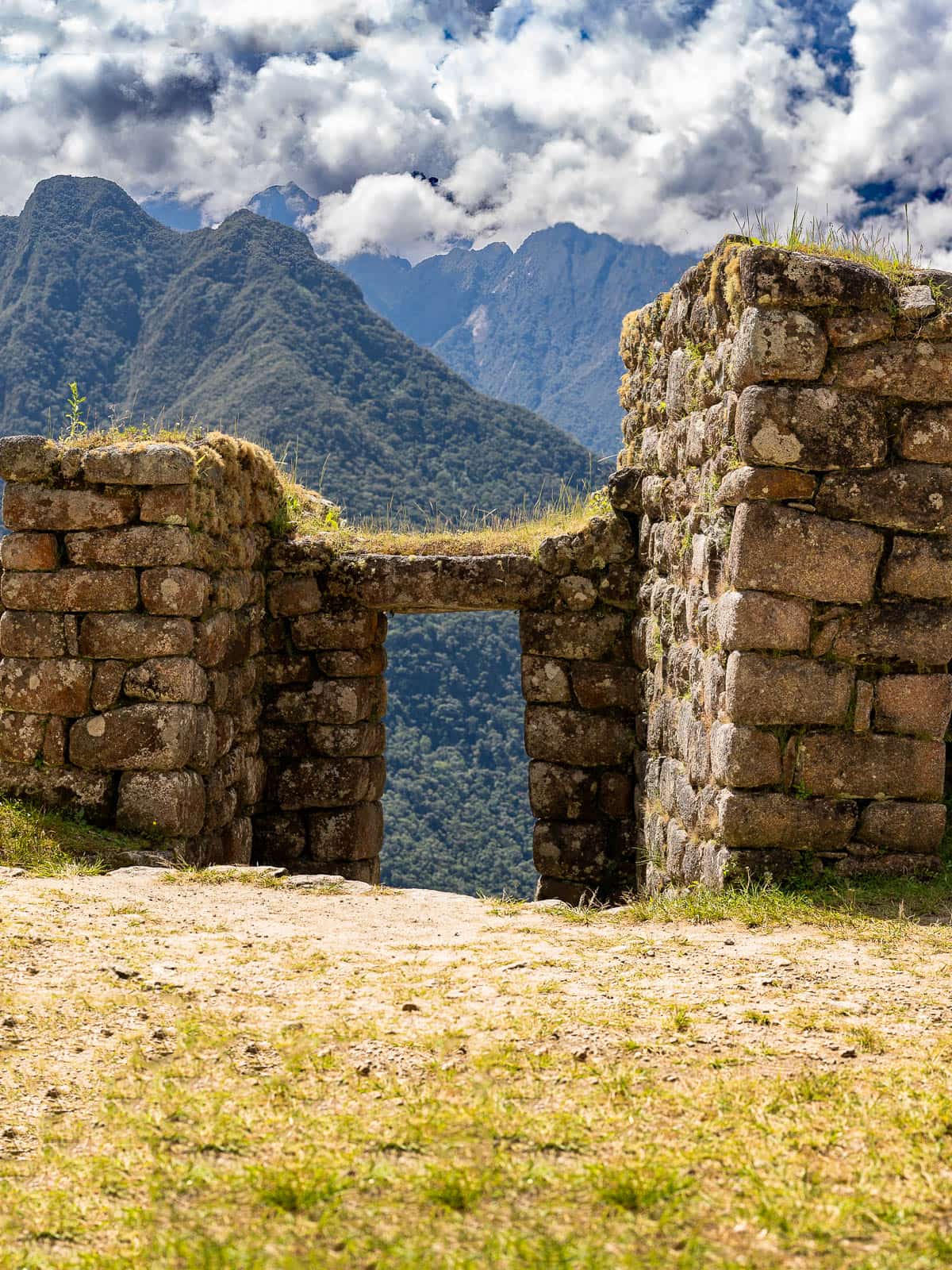 Stone doorway at Wiñay Wayna with Andes Mountains the background along the Inca Trail in Peru