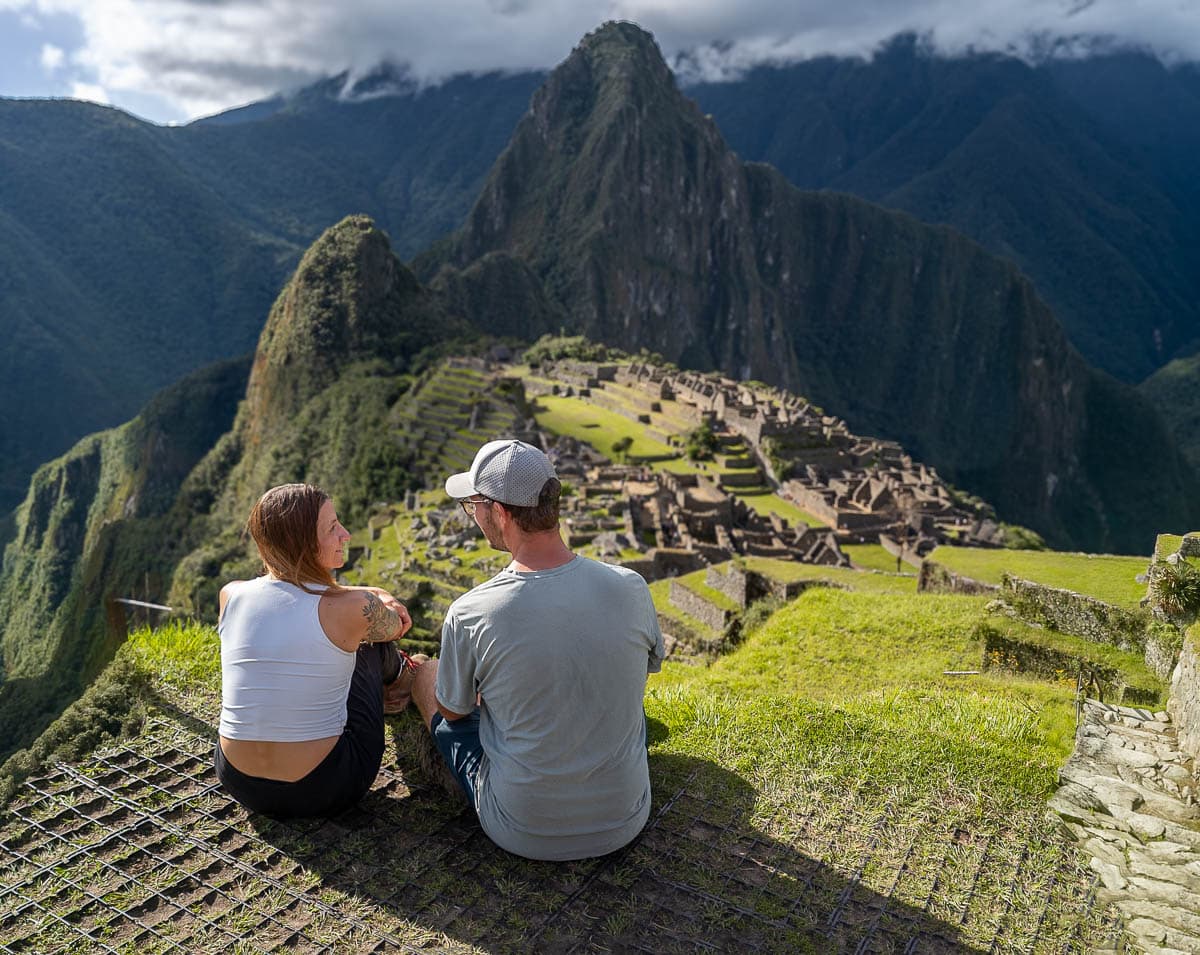 Couple sitting at an overlook with Machu Picchu in the background in Peru