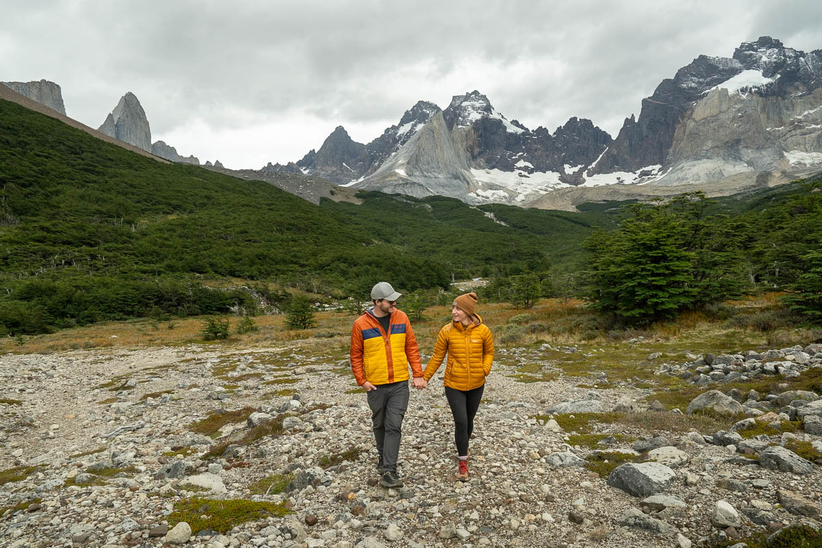 Couple holding hands and walking in front of the French Valley in Torres del Paine National Park in Chilean Patagonia