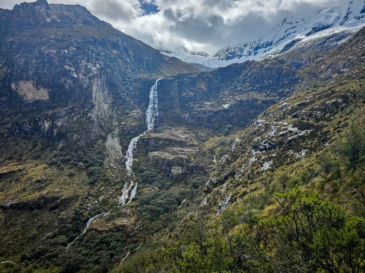Waterfall flowing down a rugged mountain from Laguna 69 hike in Huascarán National Park in northern Peru