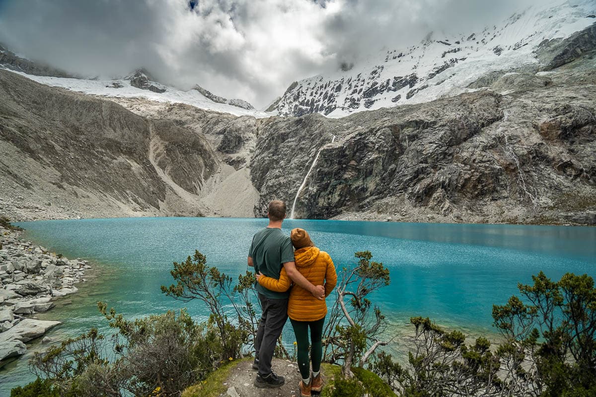 Couple looking at Laguna 69 with Cerro Chacraraju in the background in Huascarán National Park in northern Peru