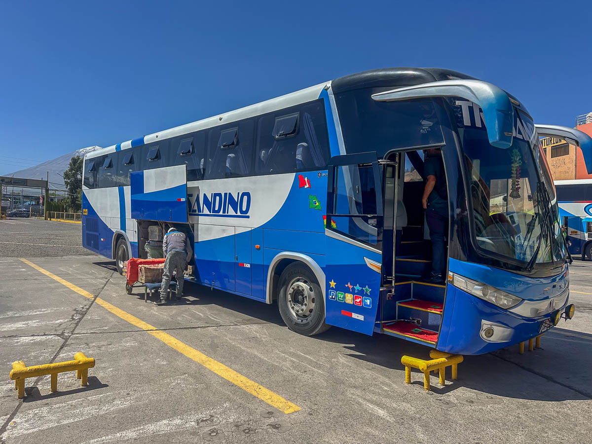 Man loading luggage into a bus in Peru