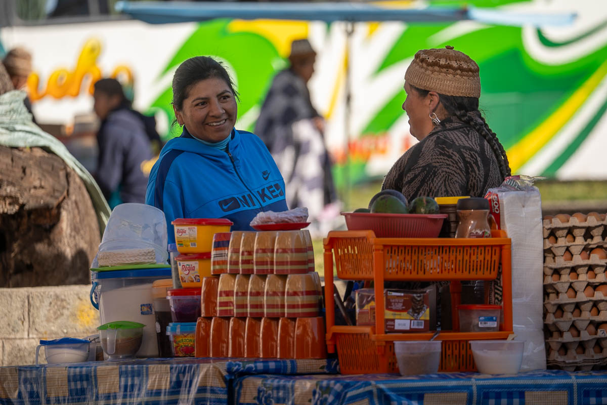 Two women speaking at a food stall in Copacabana, Bolivia