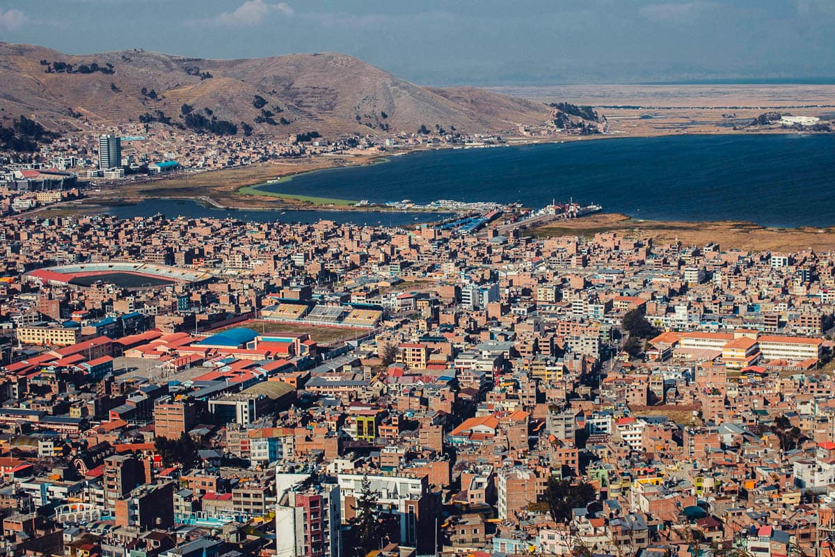 Buildings with Lake Titicaca and mountains in the background in Puno, Peru