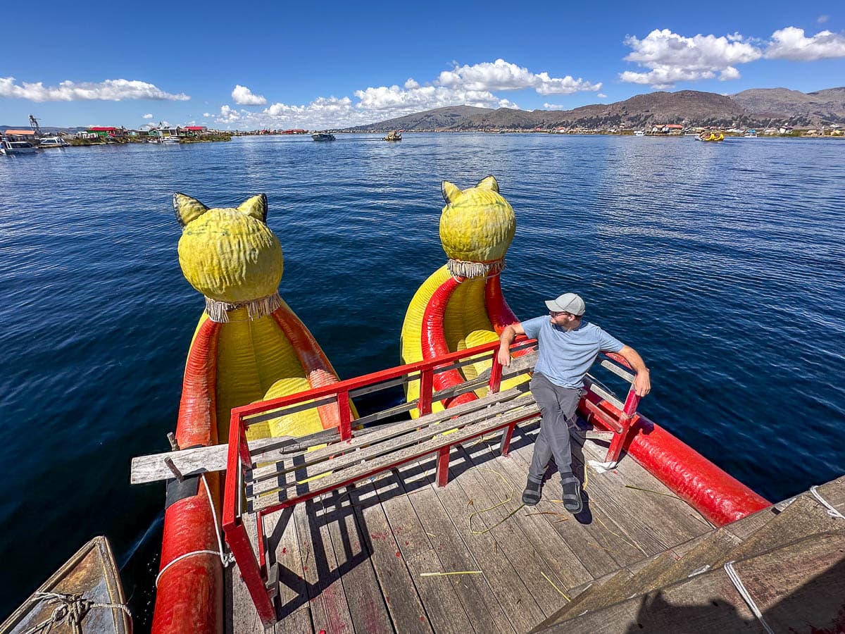 Man sitting on a balsa boat with the Uros islands near Puno, Peru