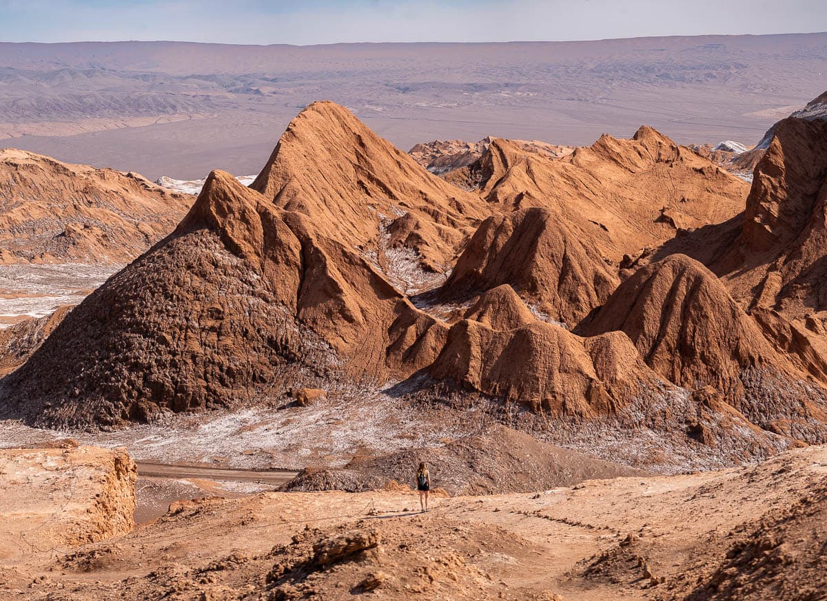 Woman standing on a Sendero Mirador Achaches with rugged mountains in the background in the Atacama Desert in Chile