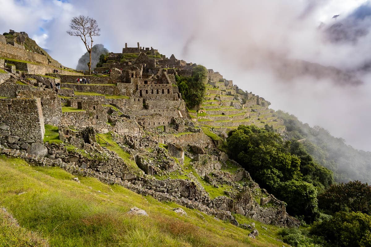 Inca ruins and agricultural ruins with moody clouds in the background at Machu Picchu in Peru
