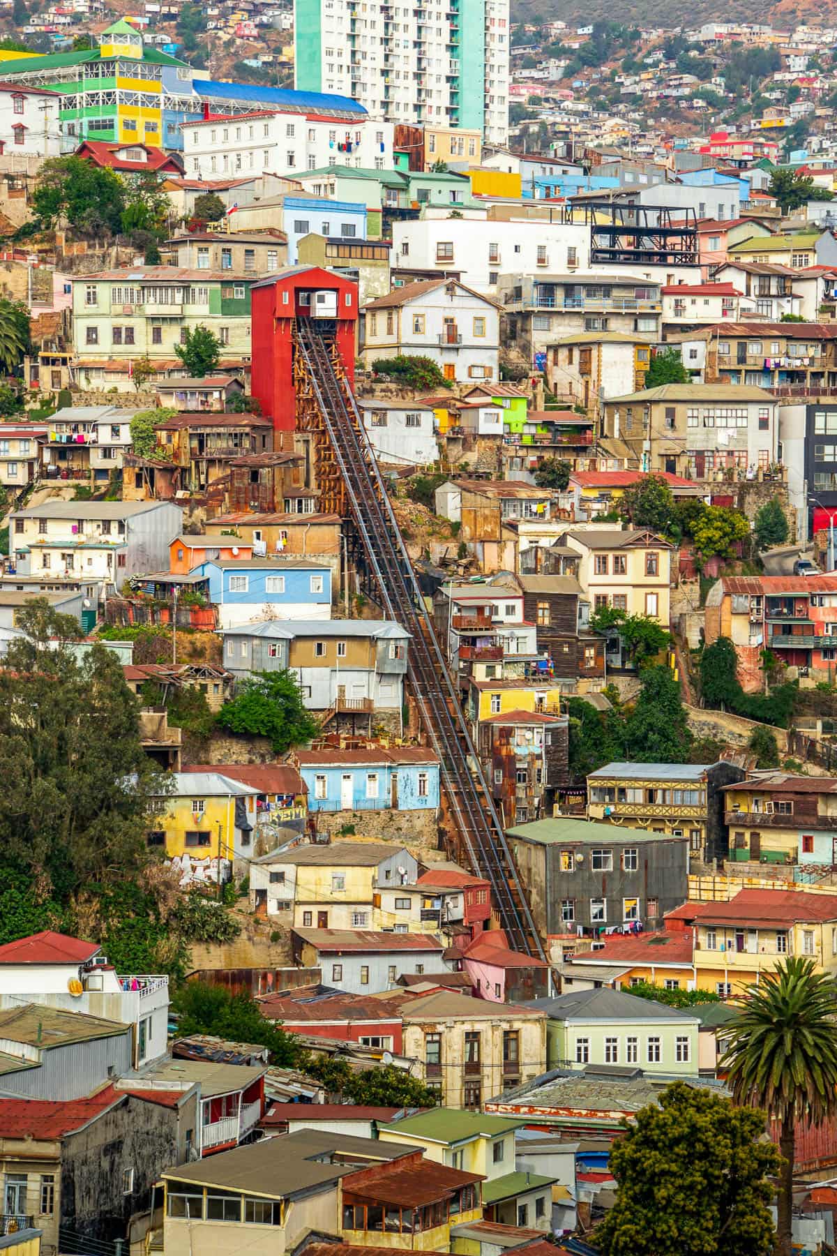 Colorful buildings and a funicular leading up a steep hillside in the Valparaiso, Chile