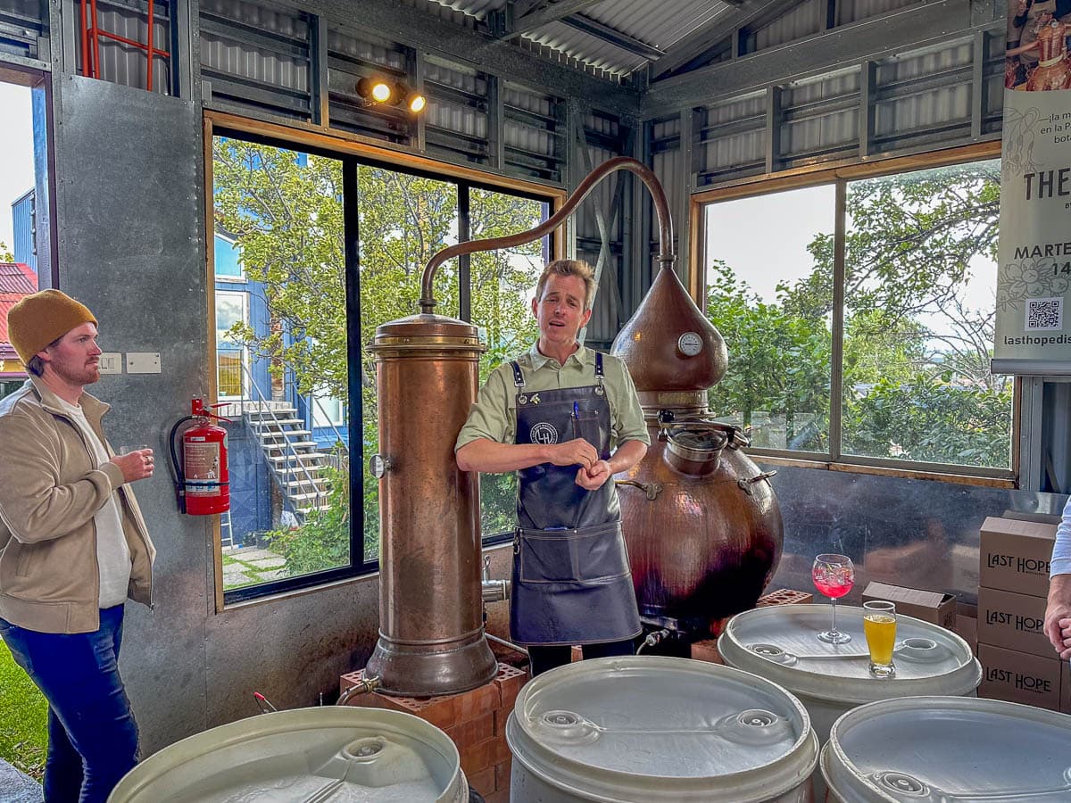 Man giving a tour at the Last Hope Distillery with distilling barrels in Puerto Natales, Chile