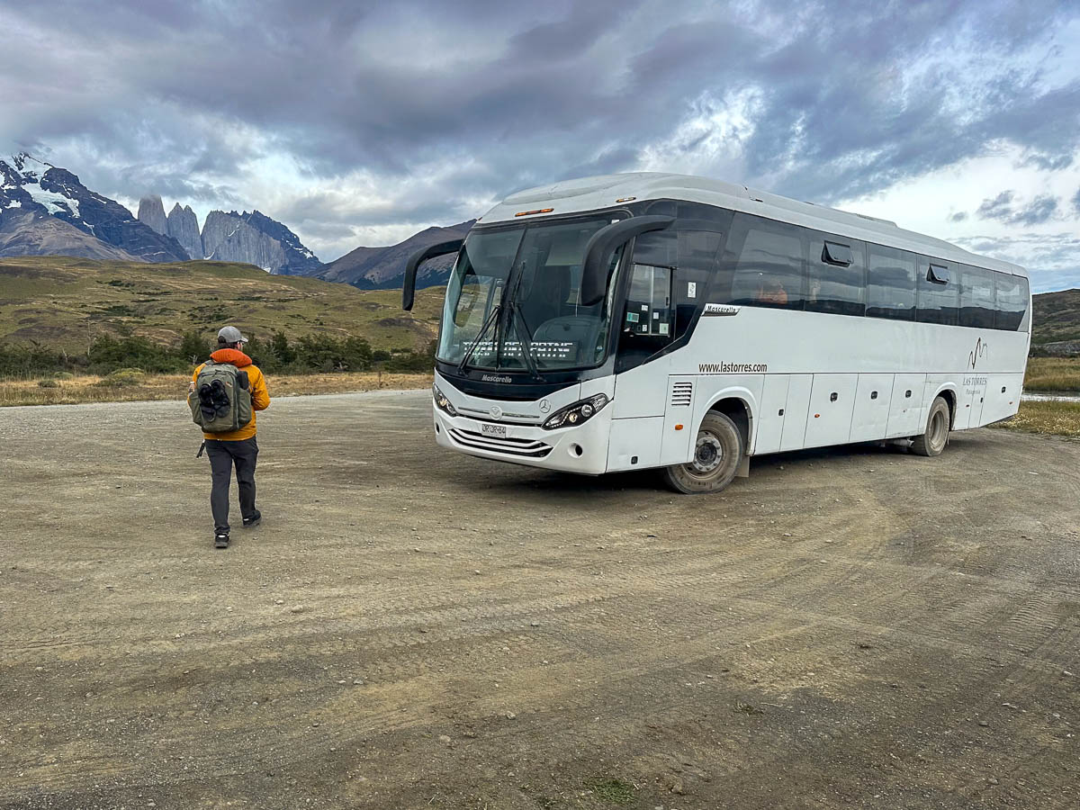 Man walking to the Hotel las Torres shuttle with mountains in the background in Torres del Paine National Park in Chile