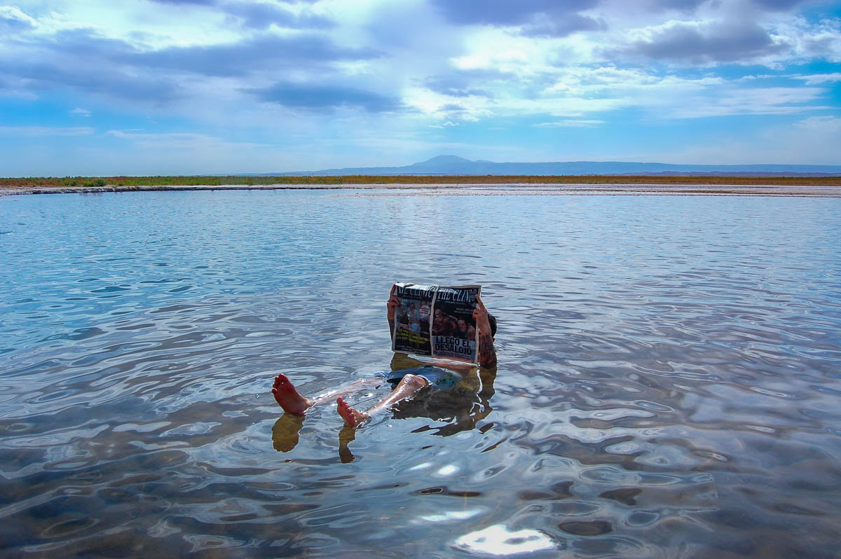 Man floating in Laguna Cejar while reading a newspaper near San Pedro de Atacama in the Atacama Desert of Chile