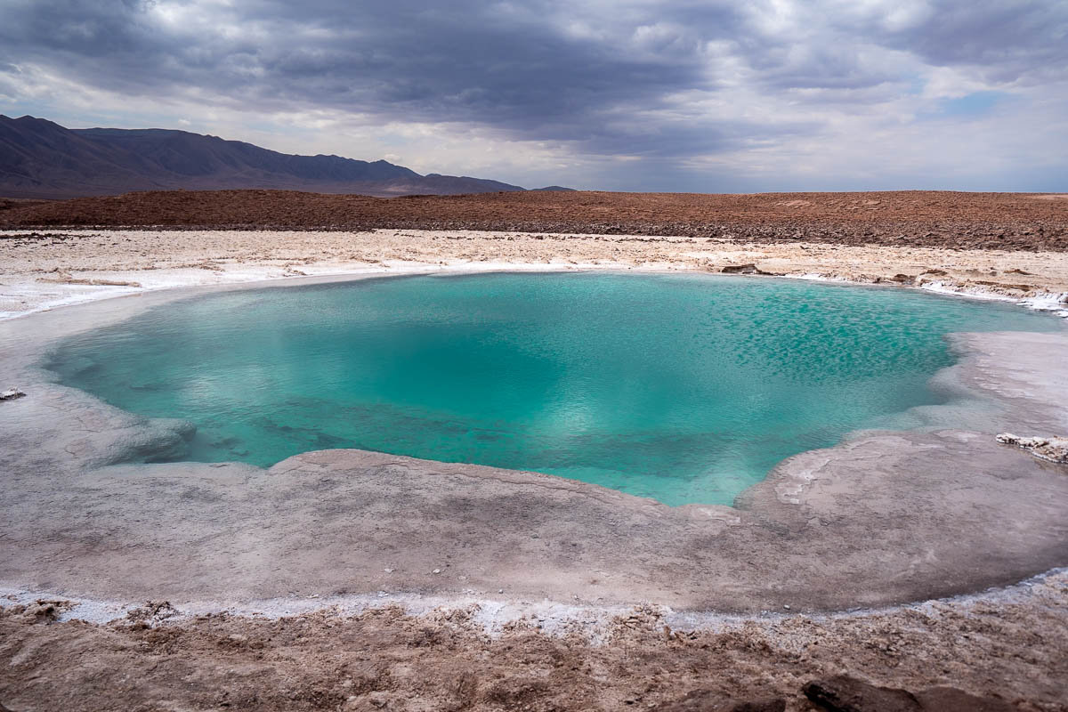 Turquoise pool surrounded by salt crust at Lagunas Escondidas de Baltinache in San Pedro de Atacama in the Atacama Desert, Chile