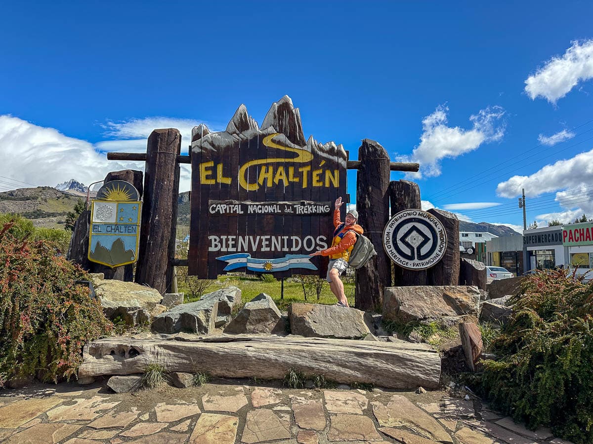 Man smiling in front of a sign for El Chalten, Argentina