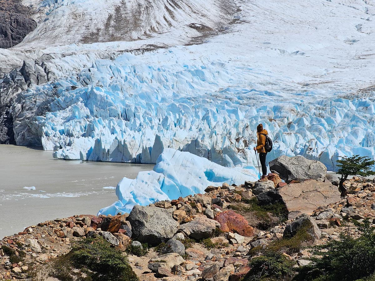 Woman standing in front of Glacier Grande on Cerro Torre along the Laguna Torre trail in El Chalten, Argentina