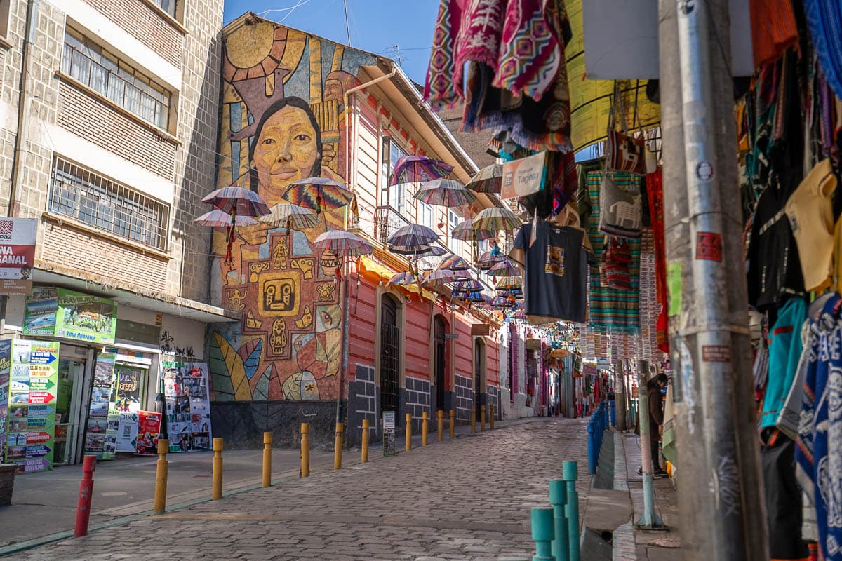 Colorful murals and umbrellas floating above a street in the Witches Market in La Paz, Bolivia
