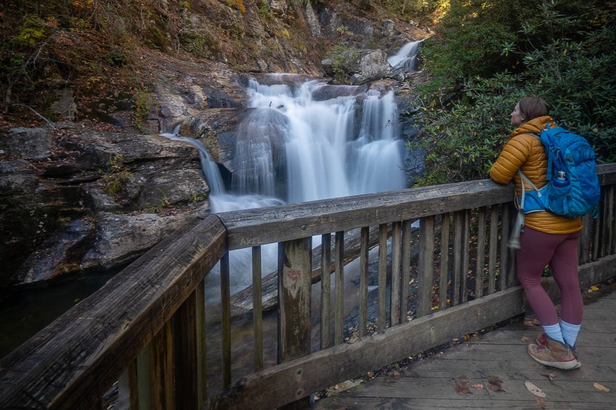 Woman overlooking a short cascade along the Dukes Creek Falls on a wooden observation platform along Dukes Creek Falls Trail near Helen, Georgia