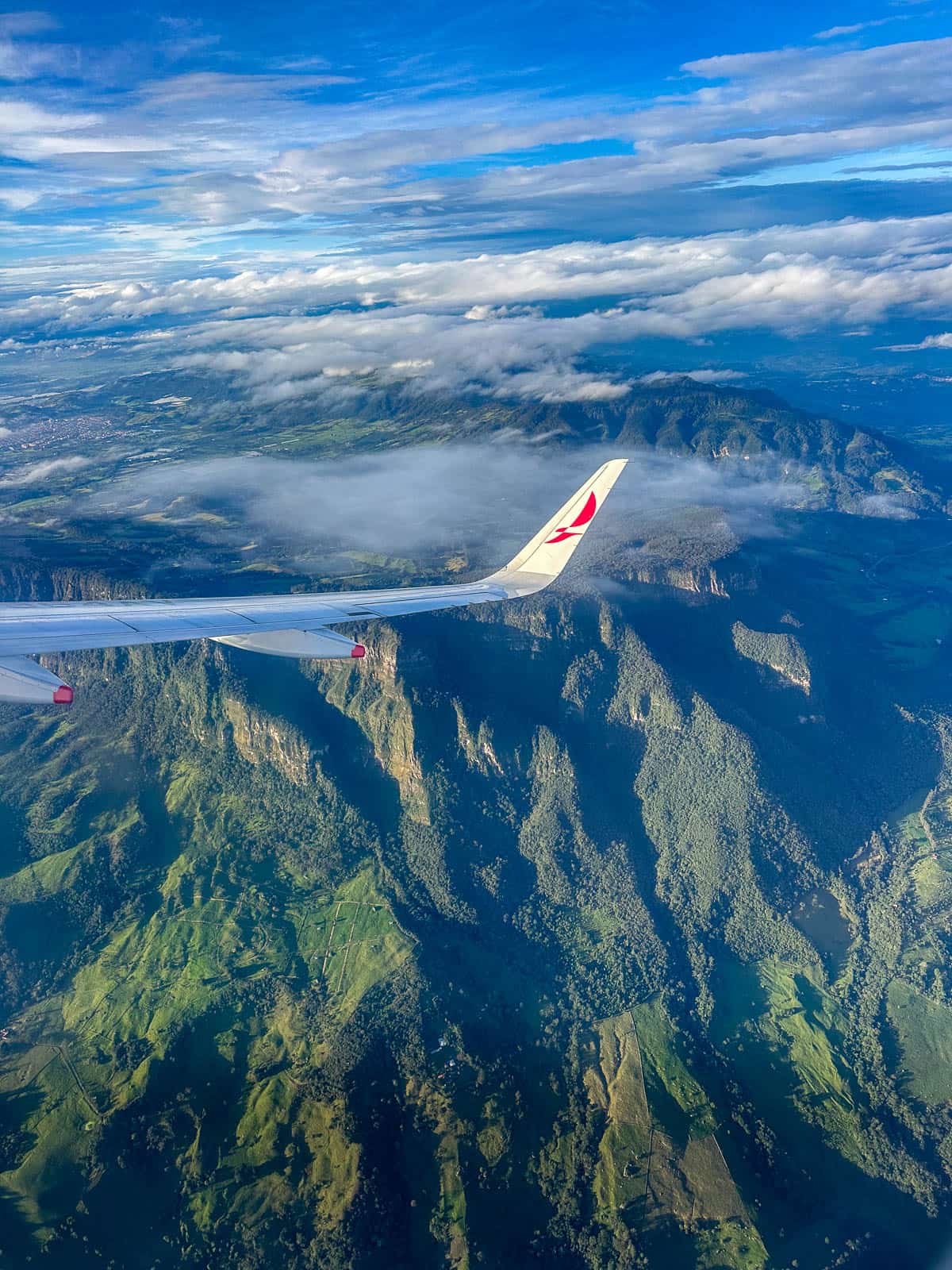 Plane wing over the green mountains near La Paz, Bolivia