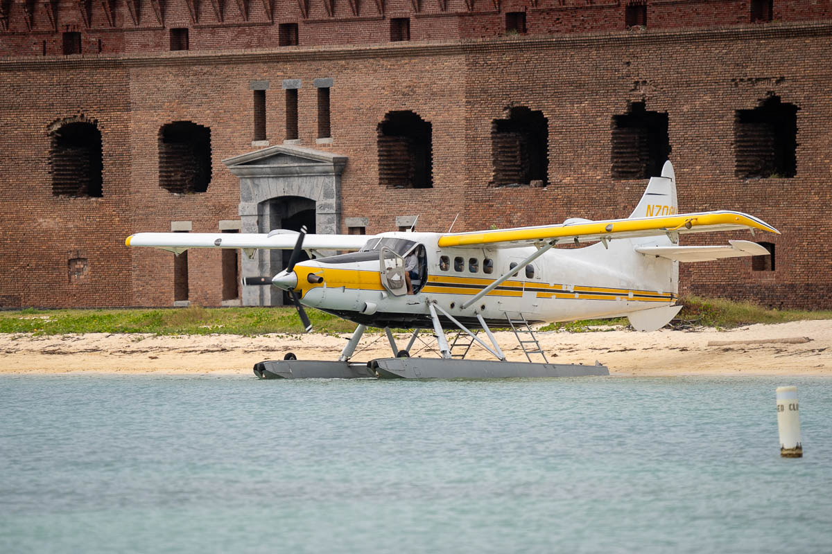 Sea plane parked on a beach with Fort Jefferson at Dry Tortugas National Park in Florida