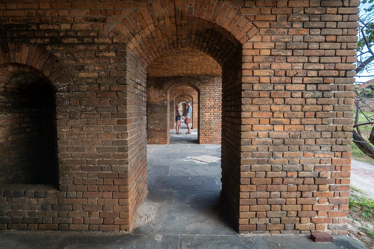 Couple holding hands in an archway in Fort Jefferson in Dry Tortugas National Park in Florida