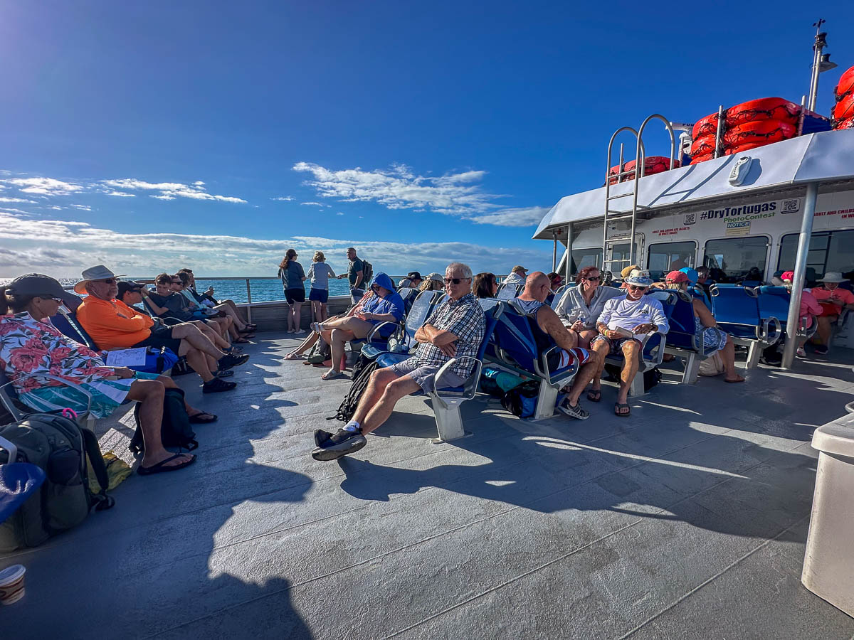 People sitting on the outer deck of Yankee Freedom ferry heading to Dry Tortugas National Park in Florida