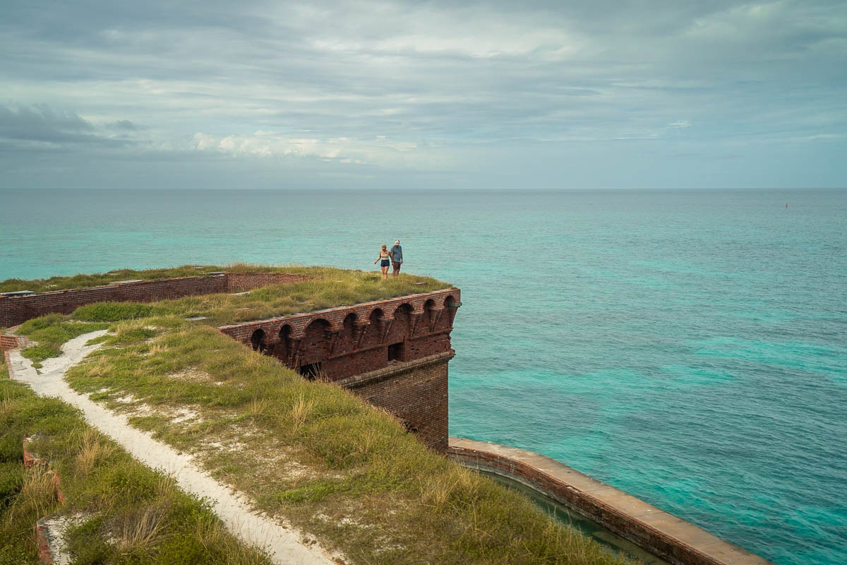 Couple walking on top of Fort Jefferson with turquoise water in the background in Dry Tortugas National Park in Florida