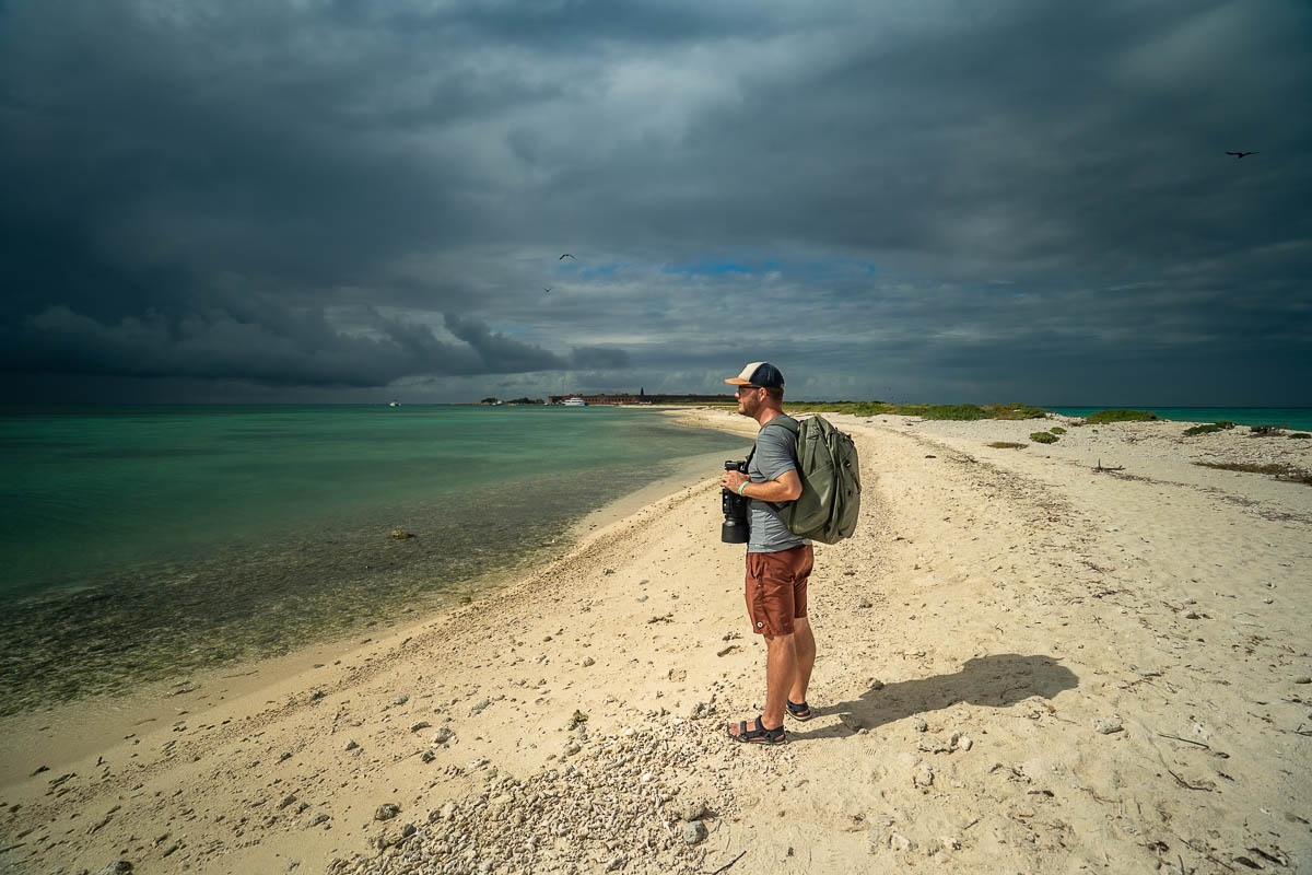 Man standing on a white sandy beach on Bush Key at Dry Tortugas National Park off Key West, Florida