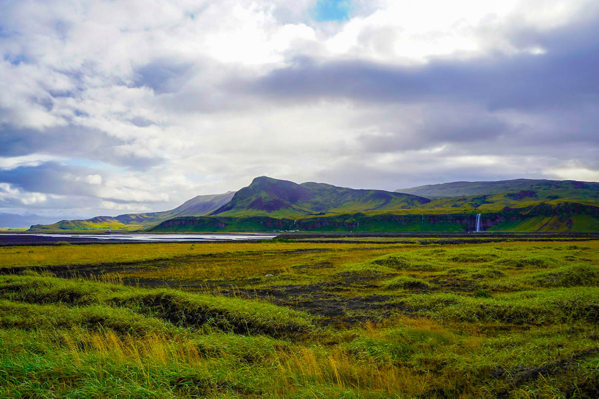 Green mountains with waterfalls along the southwestern coastline of Iceland