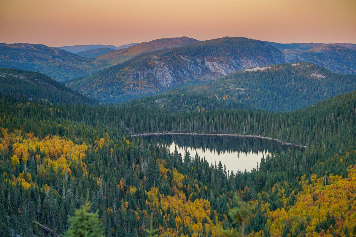 Glacial lake and mountains with fall foliage at sunset along the Mont du Dome hike in Quebec, Canada