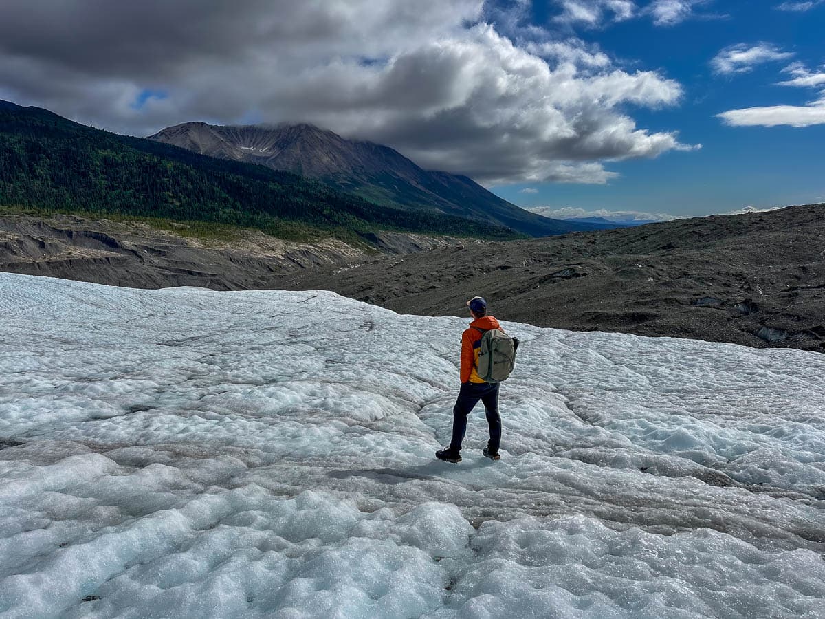 Man standing on the Root Glacier with mountains in the background in Wrangell-St. Elias National Park, Alaska
