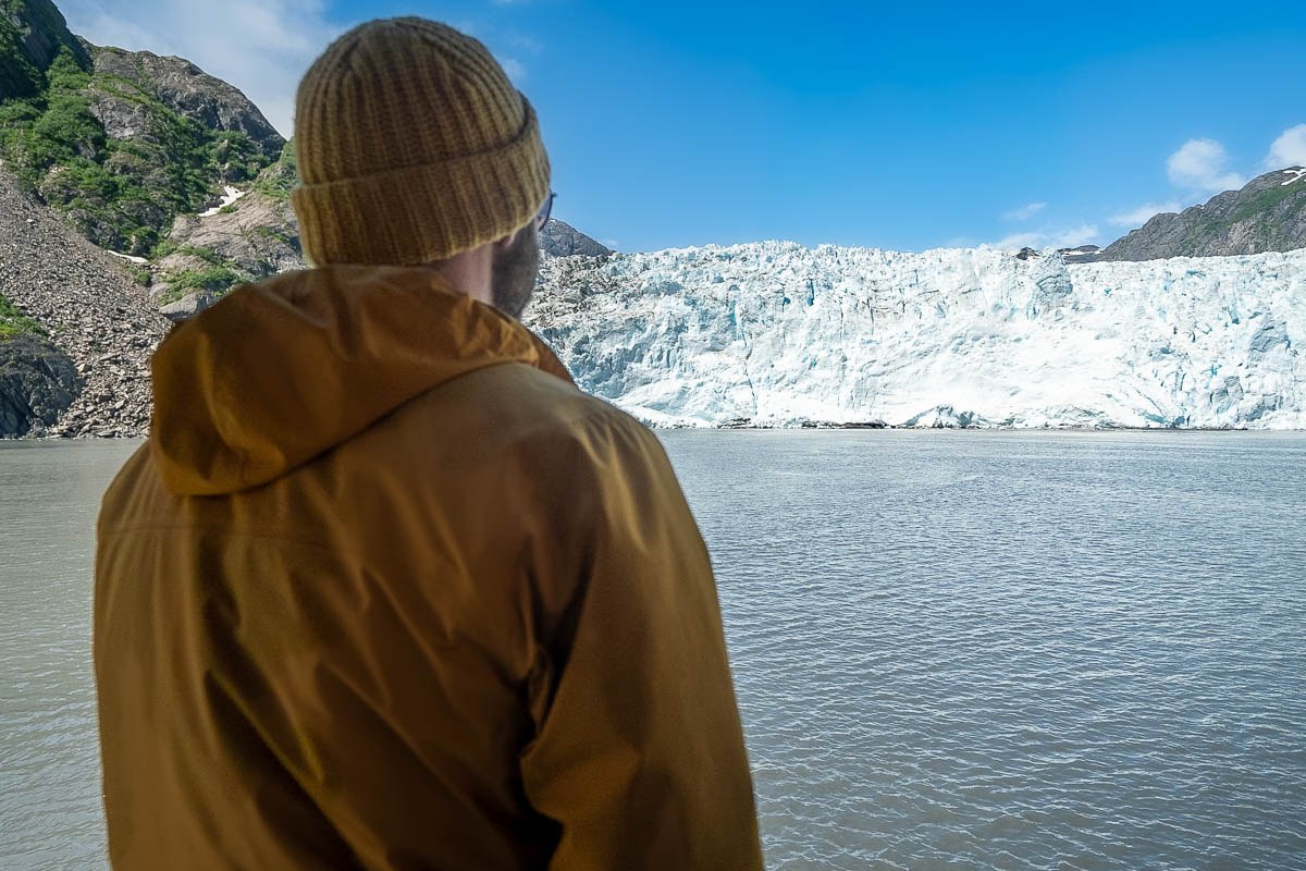 Man standing on a boat looking at a glacier in Kenai Fjords National Park, Alaska