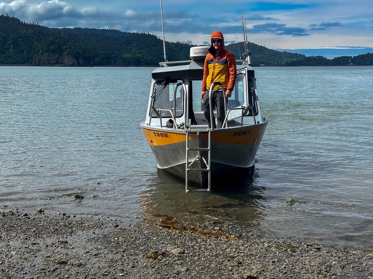 Man standing on the deck of a water taxi along the Saddle trail in Kachemak Bay State Park in Alaska