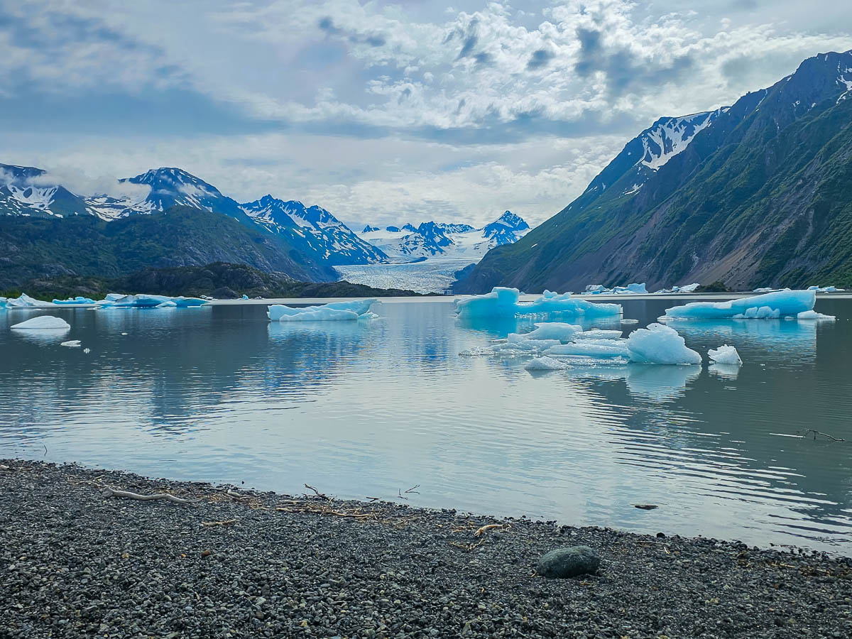 Icebergs floating in Grewingk Glacier Lake with mountains in the background in Kachemak Bay State Park, Alaska
