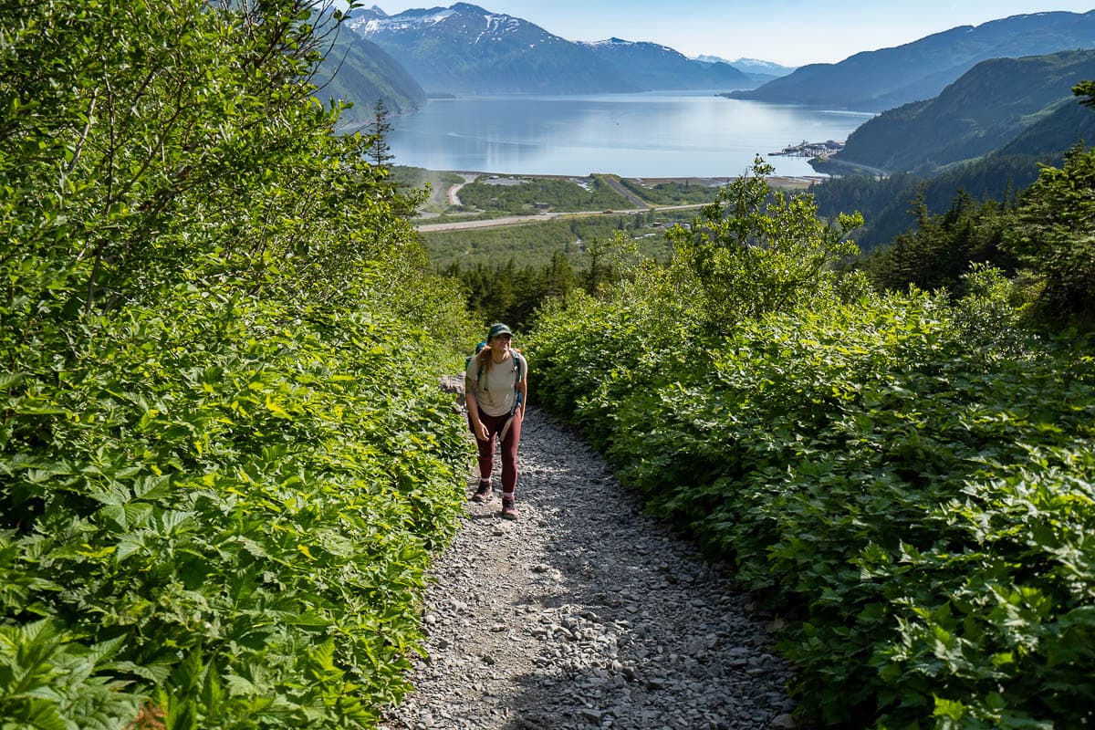 Woman climbing up the Portage Pass Trail with mountains of the Prince William Sound in Whittier, Alaska