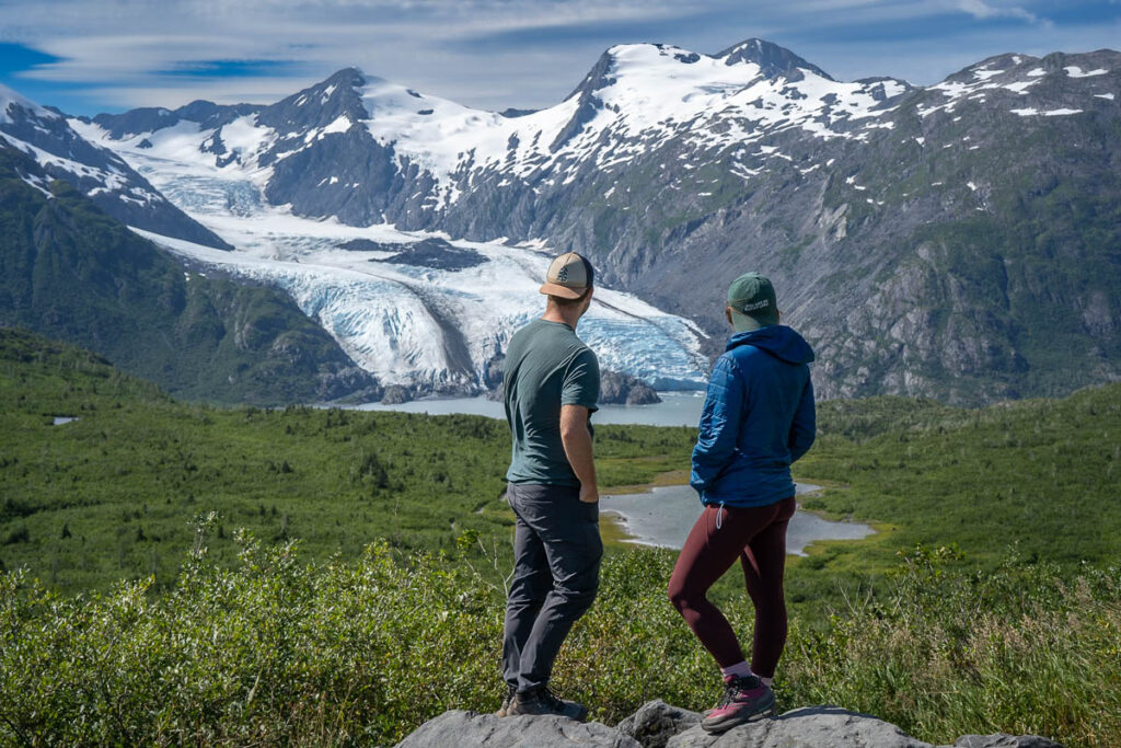 Couple standing at an overlook with the Portage Glacier in the background along the Portage Pass Trail in Whittier, Alaska